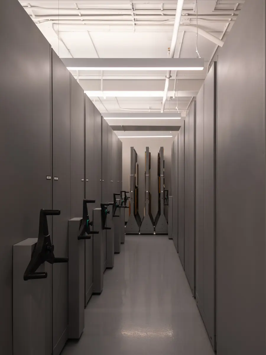 A narrow aisle between mobile archive shelves