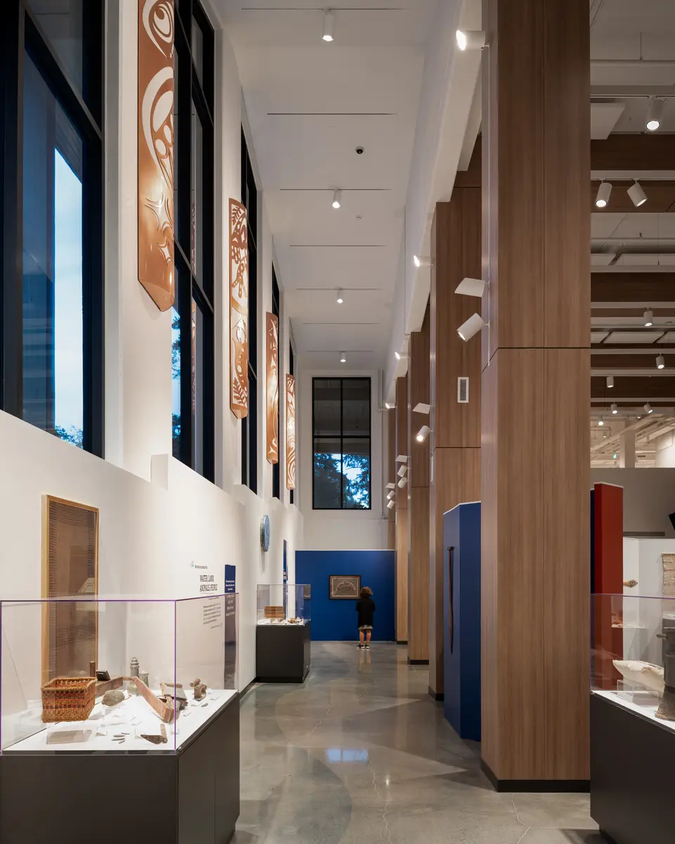 A row of display cases under the timber structure