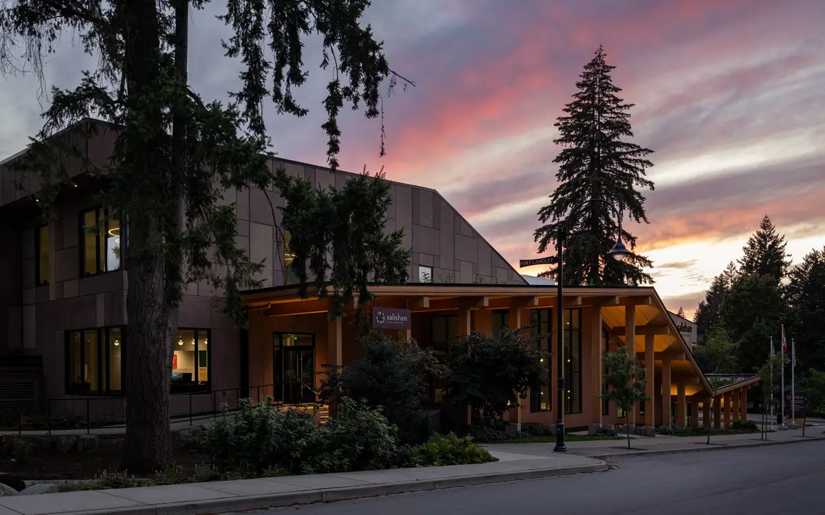 The building at dusk through the trees, the canopy lit