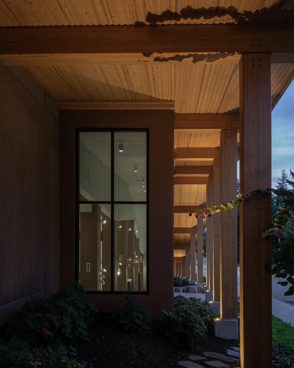 The colonnade at dusk, warm light under the soffit