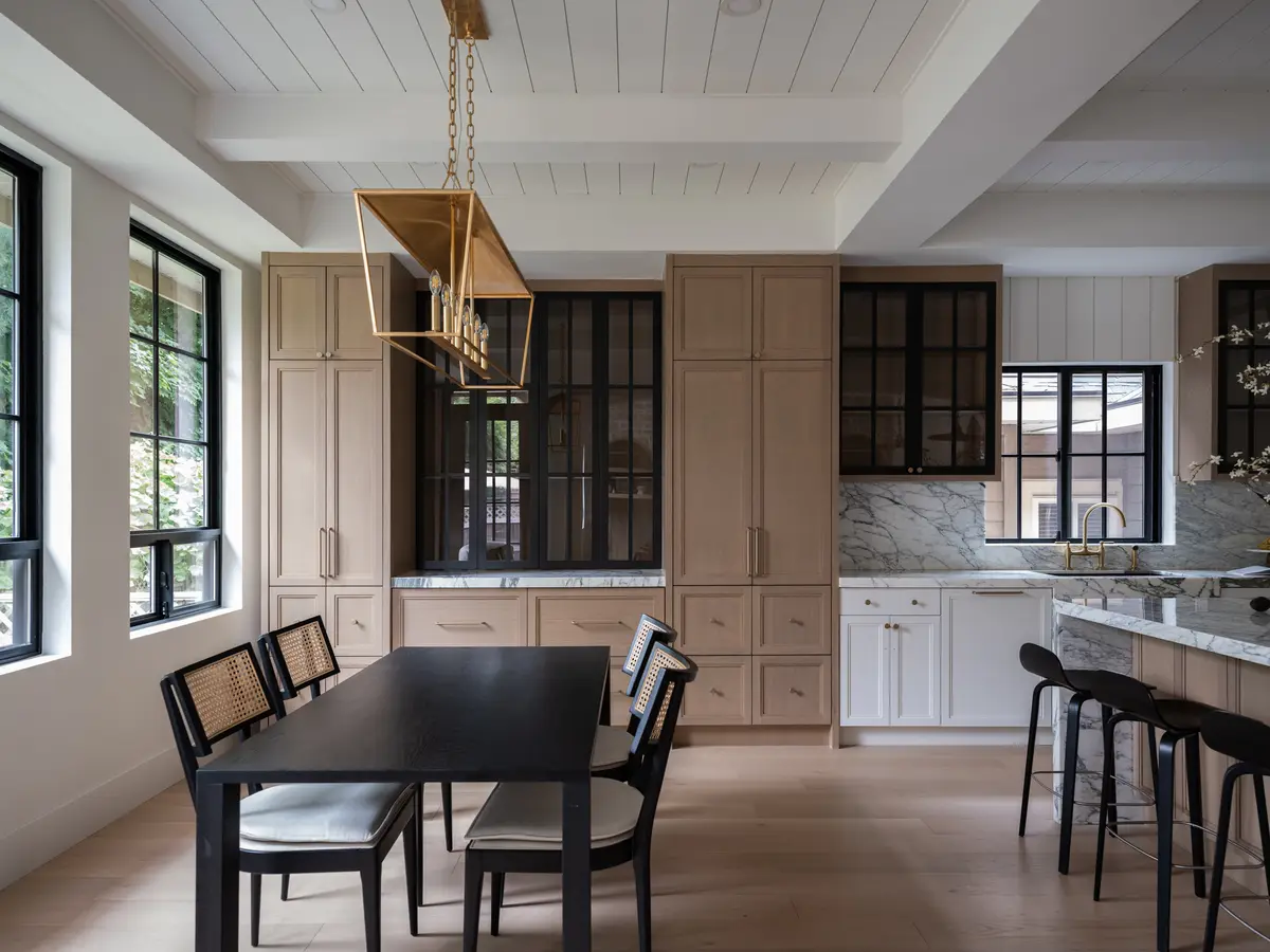 A dark dining table with the kitchen beyond