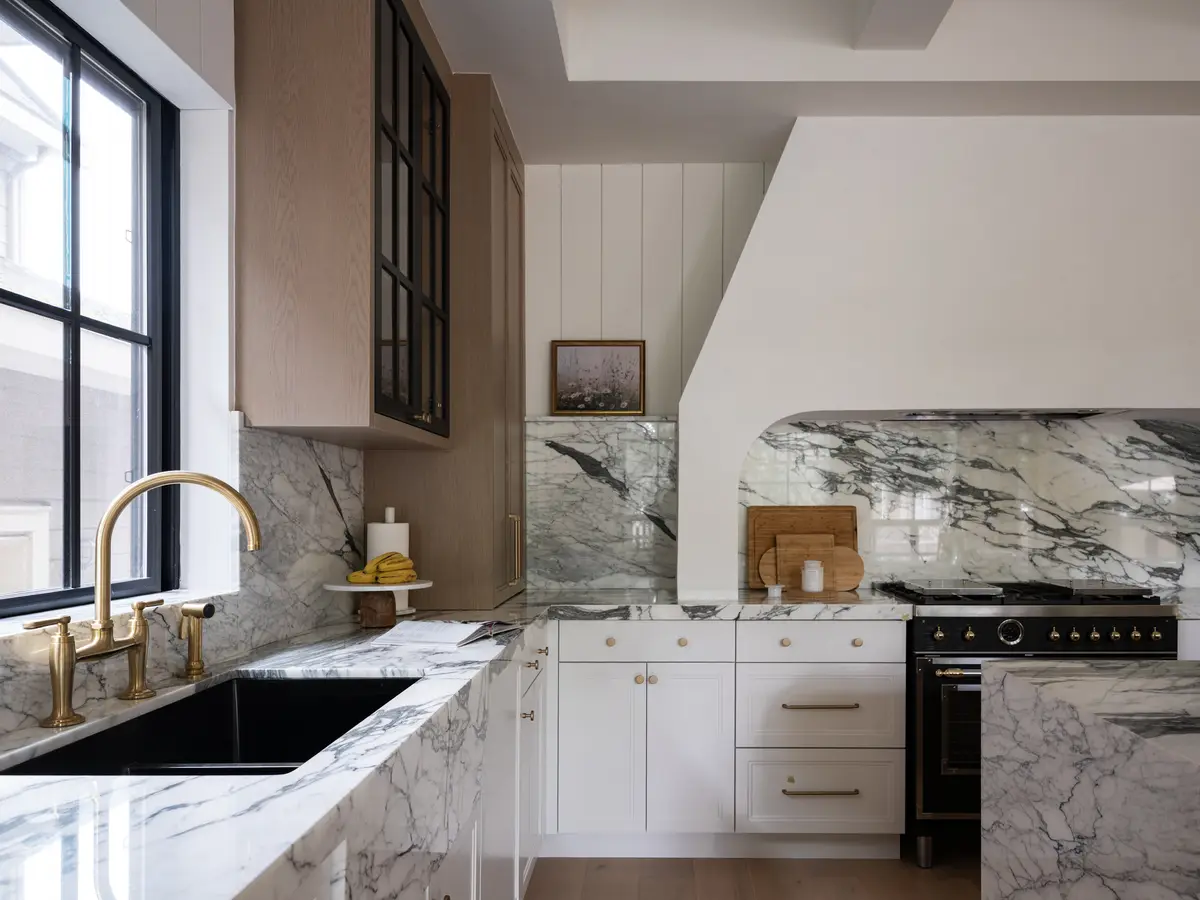 The sink in the stone counter, black-framed windows above
