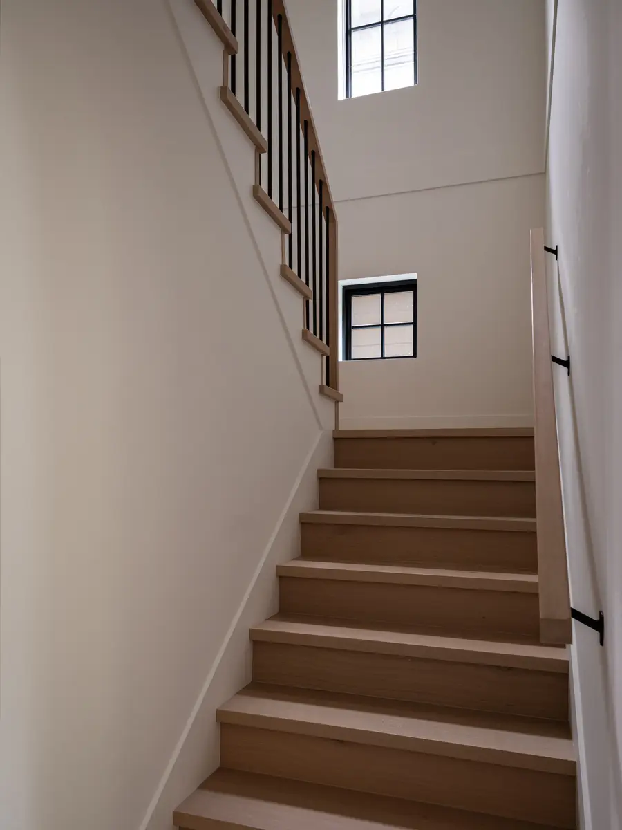 A wood stair rising to a small window
