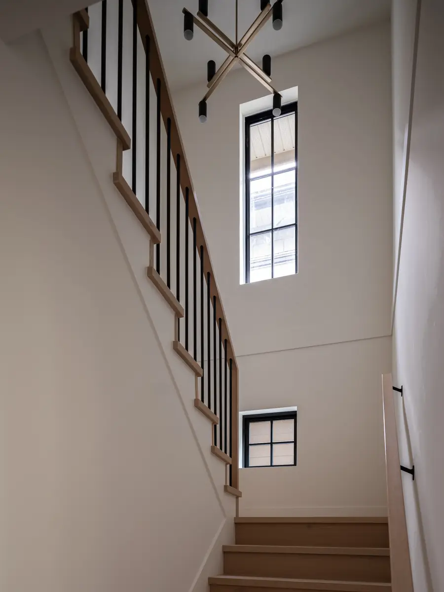 The tall stair hall, a chandelier and a high window