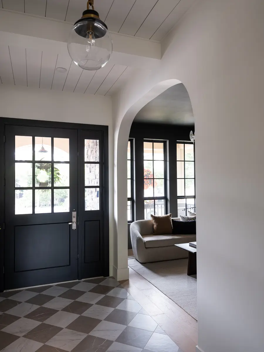 The black front door and an arch into the living room