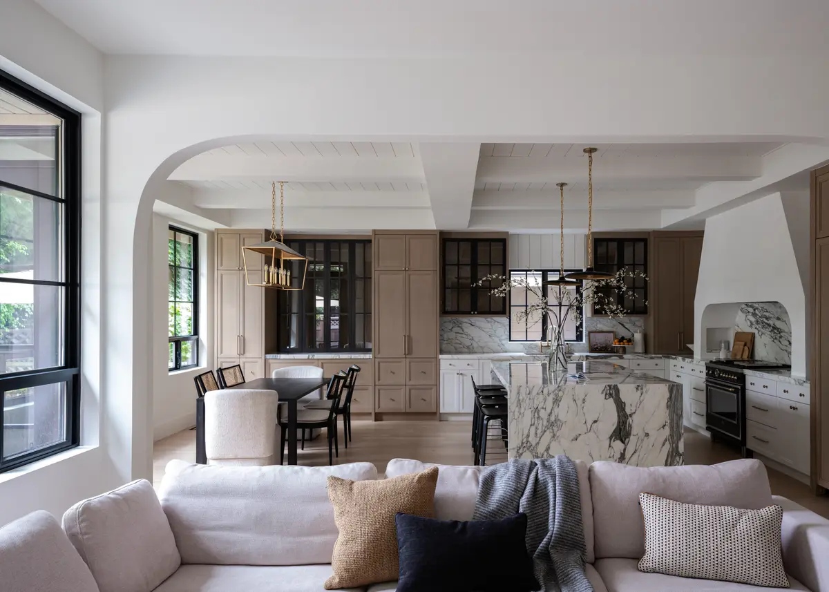 A sofa looking through arches to the kitchen