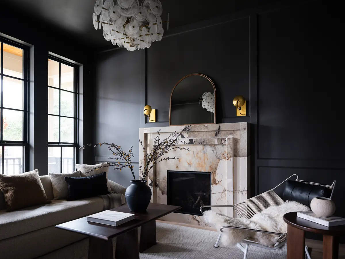 A dark sitting room, a stone fireplace and a low table